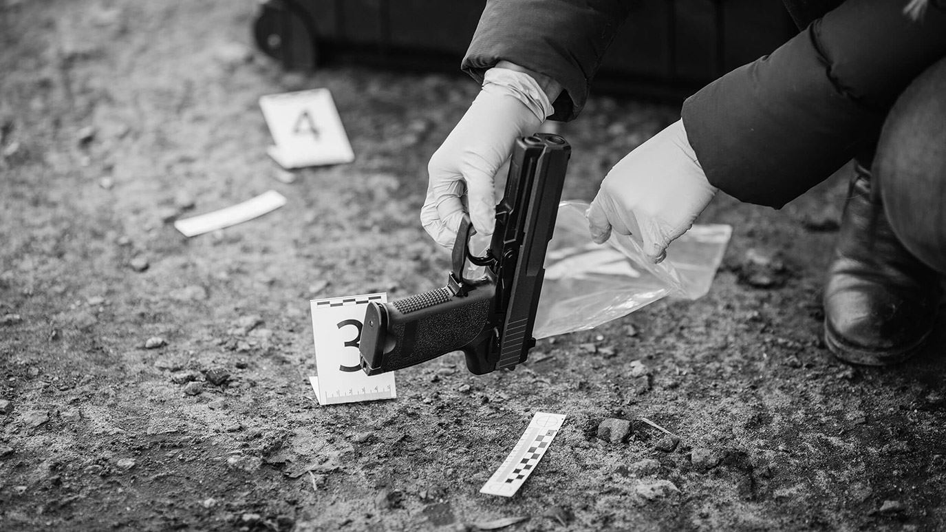 investigator holding evidence at violent crime scene